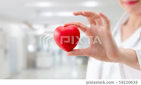 Doctor holding a red heart at hospital office. 59220638