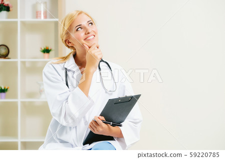 Young female doctor working in hospital office. 59220785