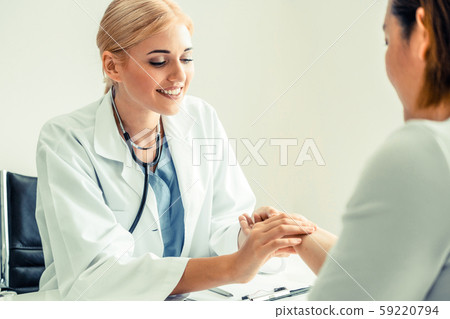 Woman Doctor and Female Patient in Hospital Office Woman Doctor and Female Patient in Hospital Office 59220794