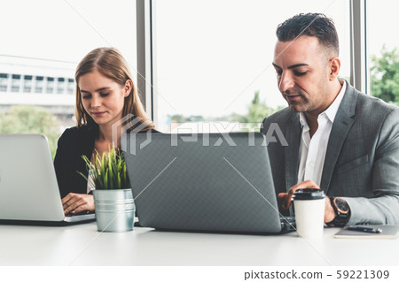 Businessman and businesswoman working in office. 59221309