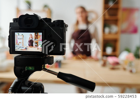 Contemporary girl on display of home camera recording soap making master class Contemporary girl on display of home camera recording soap making master class 59228453