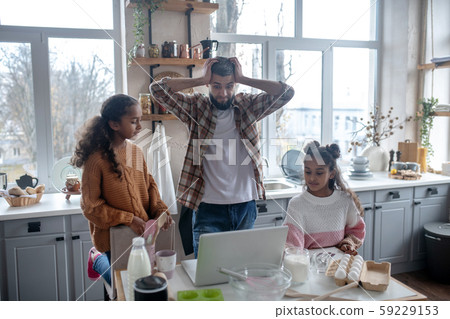 Father feeling concerned before cooking pie for the first time