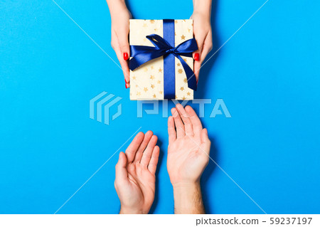 Top view of a gift in male and female hands on Top view of a gift in male and female hands on 59237197