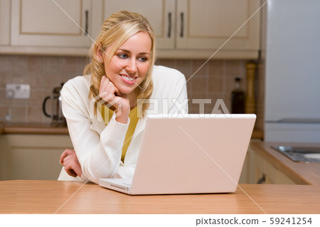 Beautiful Teenage Girl Young Woman Using Laptop in Her Kitchen Beautiful Teenage Girl Young Woman Using Laptop in Her Kitchen 59241254