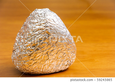 One triangular rice ball wrapped in aluminum foil. One triangular rice ball wrapped in aluminum foil. 59243865