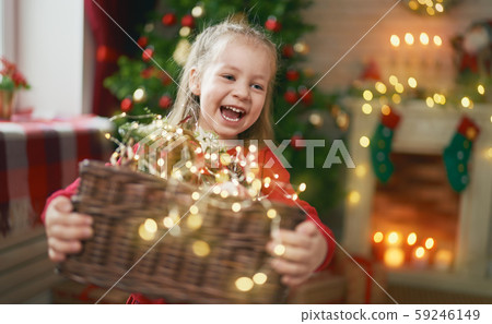 child with garlands near tree at home. child with garlands near tree at home. 59246149