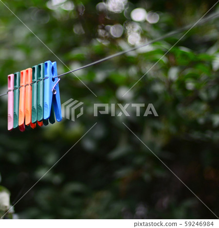Clothespins on a rope hanging outside house and 59246984