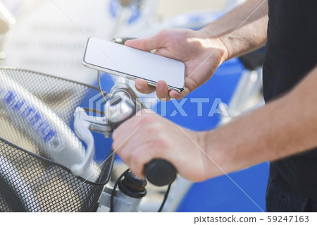Young cyclist searching GPS coordinates on smartphone 59247163