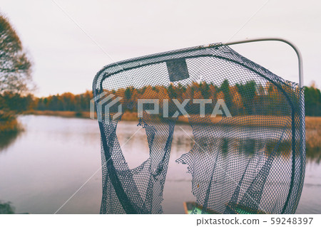 Torn fish net on the lake 59248397
