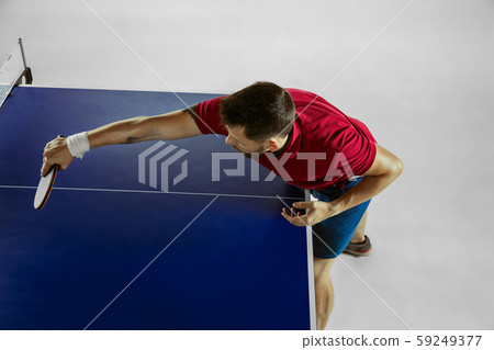 Young man playing table tennis on white studio background 59249377