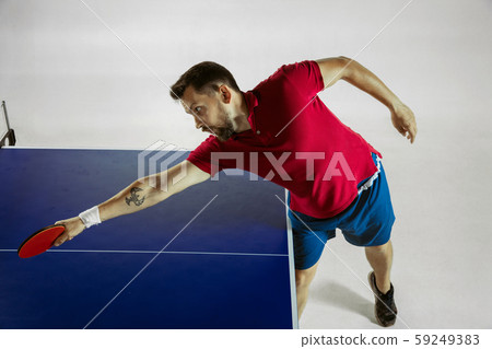 Young man playing table tennis on white studio background 59249383