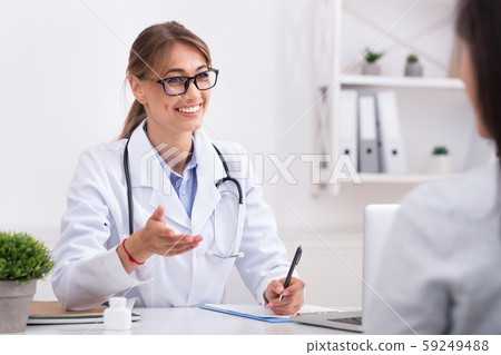 Lady Doctor Talking With Unrecognizable Patient During Appointment In Office Lady Doctor Talking With Unrecognizable Patient During Appointment In Office 59249488