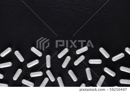 white medicine capsules on black background with copy space white medicine capsules on black background with copy space 59250497