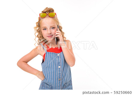 Picture of happy child with fair red curly hair talking on the phone with friend Picture of happy child with fair red curly hair talking on the phone with friend 59250660
