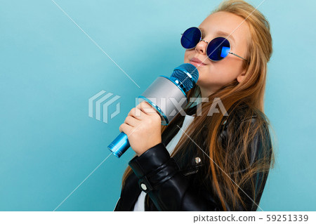 photo of a teenage girl in blue sunglasses against a blue wall, a girl with a microphone in a rocker photo of a teenage girl in blue sunglasses against a blue wall, a girl with a microphone in a rocker 59251339