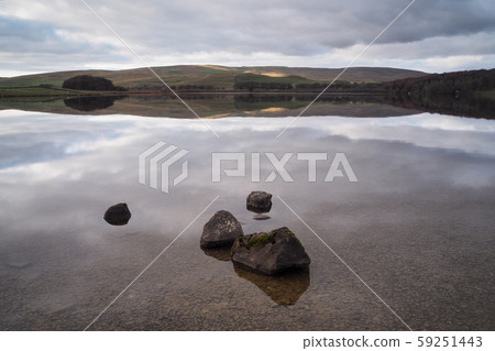 Serene water of Malham Tarn with the reflection of the afternoon sun on the hills, Yorkshire Dales, 59251443