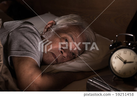 Depressed senior man lying in bed cannot sleep from insomnia 59251458