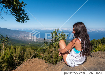 young girl looks at the landscape with her dog 59251651