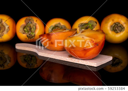 Sweet orange persimmon isolated on black glass Sweet orange persimmon isolated on black glass 59253384