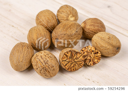 Dry brown nutmeg on grey wood Dry brown nutmeg on grey wood 59254296