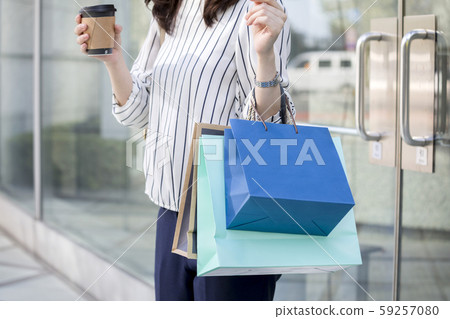 購物後離開商店的年輕女子 59257080