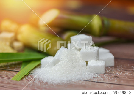 White sugar cubes and sugar cane on wooden table White sugar cubes and sugar cane on wooden table 59259860