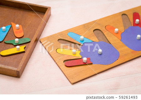 Top view closeup of colorful wooden Montessori sensorial material learning, hands and fingers. Preschool and Kindergarten educational toys, Logical sense, Cognitive skills, Learn Through Play tools. Top view closeup of colorful wooden Montessori sensorial material learning, hands and fingers. Preschool and Kindergarten educational toys, Logical sense, Cognitive skills, Learn Through Play tools. 59261493