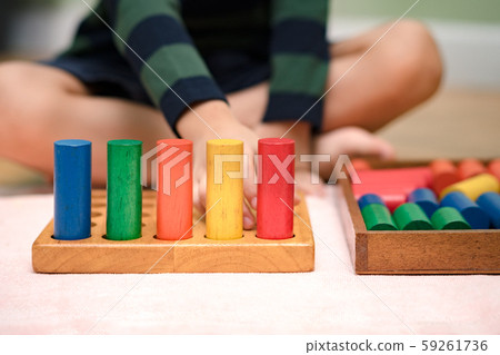 A little kid (3-6) learning about size, orders, sorting, arranging by engaged colorful wooden blocks. Educational toys, Cognitive skills, Sensorial activity, Children development concept. A little kid (3-6) learning about size, orders, sorting, arranging by engaged colorful wooden blocks. Educational toys, Cognitive skills, Sensorial activity, Children development concept. 59261736