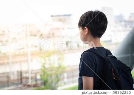 Portrait of an asian tween student boy (12 -15 years old) standing alone lost in thought on the walkway at school. Bullying, Teen problem, Physical or emotional harm, Loneliness, Withdrawn, Introvert. 59262230