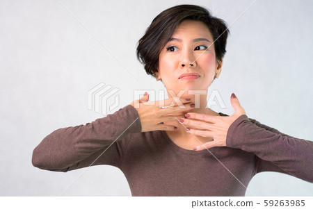 Portrait of nice charming attractive middle aged asian woman worried  about aging neck wrinkles, she cover with her hands. Anti-aging, Face self-massage, Beauty skin care, Signs of aging concept. 59263985