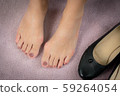 Closeup : Bare feet of woman, she take off her shoes to release pain after long day wearing pointy and narrow shoes  -  Medical condition called bunions (Hallux valgus) Woman's health concept. 59264054