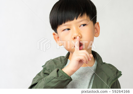 An adorable little boy touch his forefinger to his lip and do the shh.. expression. Keep quoted, Mute, Secret, Silent, Child development, No sound Concept 59264166