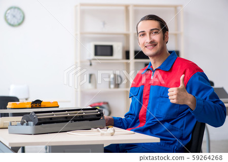Young repairman repairing air-conditioner at warranty center Young repairman repairing air-conditioner at warranty center 59264268