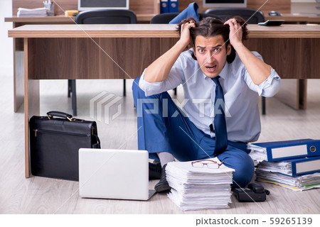 Young male employee and too many work in the office Young male employee and too many work in the office 59265139