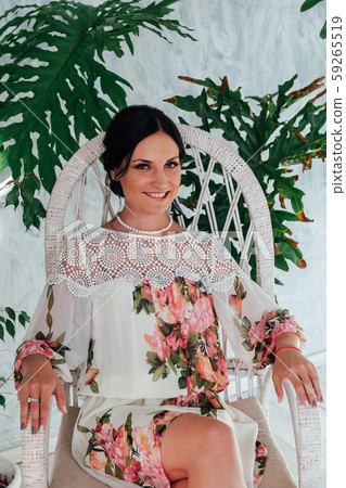Portrait of a beautiful brunette woman with large green leaves of the plant Portrait of a beautiful brunette woman with large green leaves of the plant 59265519
