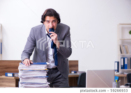 Young male employee unhappy with excessive work 59266933