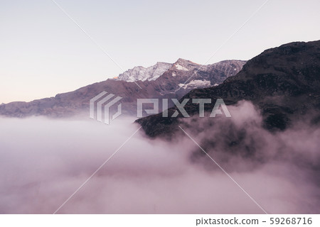 Snow covered mountain peaks in the clouds. Snow covered mountain peaks in the clouds. 59268716