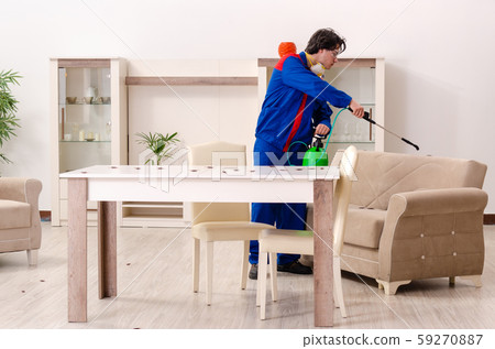 Young contractor doing pest control at home 59270887