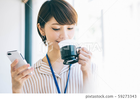 女人在工作休息時看著智能手機喝咖啡 59273343