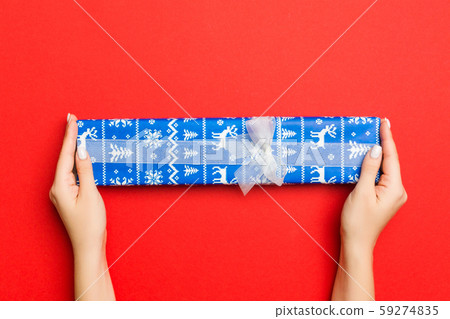 Female's hands holding striped gift box with Female's hands holding striped gift box with 59274835