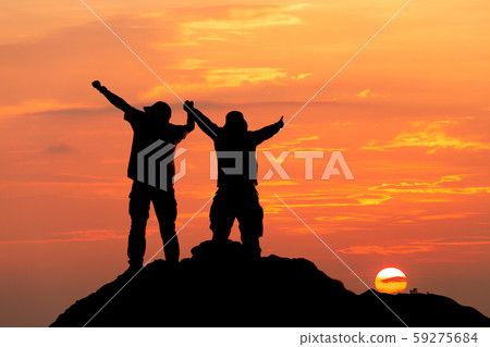 Silhouette of man hold up hands on the peak of 59275684