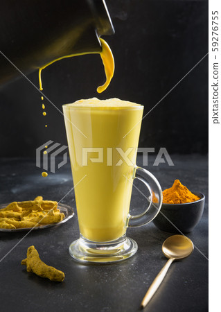 Pouring glass of ayurvedic golden turmeric latte Pouring glass of ayurvedic golden turmeric latte 59276755