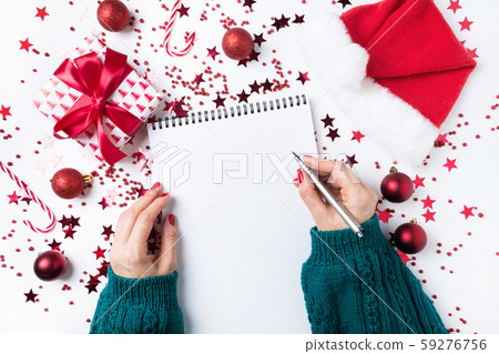 Woman in green sweater writting checklist of plans Woman in green sweater writting checklist of plans 59276756