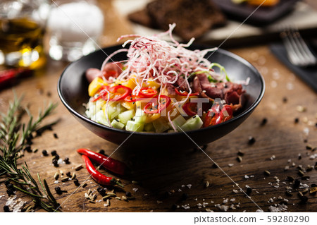 Poke with beef served in a black bowl in restaurant Poke with beef served in a black bowl in restaurant 59280290