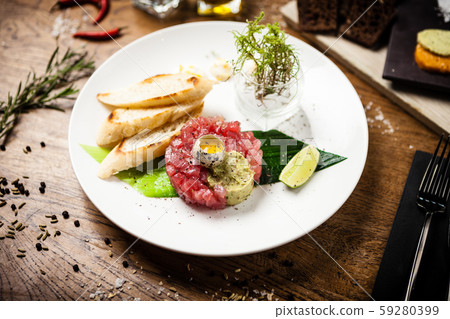 Tuna tartare served on a plate in restaurant 59280399