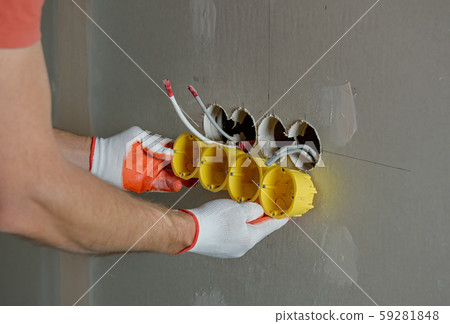 Installing socket boxes into drywall. 59281848