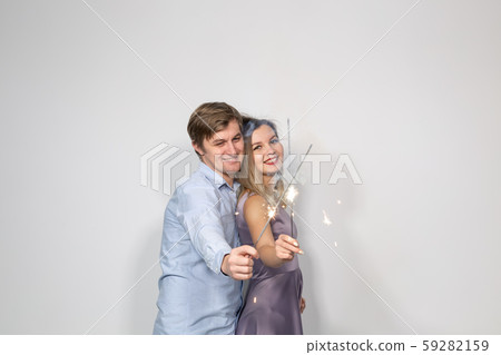 Holidays, family and celebrations concept - young couple hugging with crossed bengals light or Holidays, family and celebrations concept - young couple hugging with crossed bengals light or 59282159
