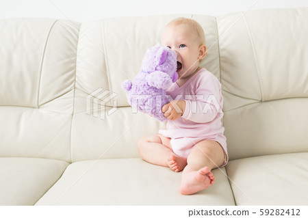Child, childhood and kids concept - Portrait of charming baby girl on the couch Child, childhood and kids concept - Portrait of charming baby girl on the couch 59282412