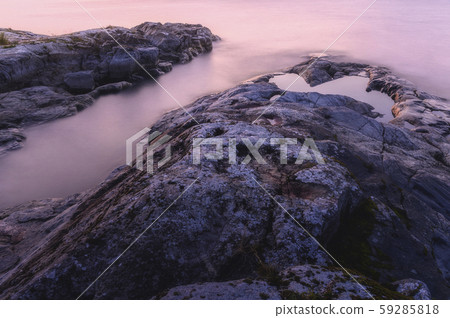 Close-up of rocks and water. Moody purple sunrise. Close-up of rocks and water. Moody purple sunrise. 59285818