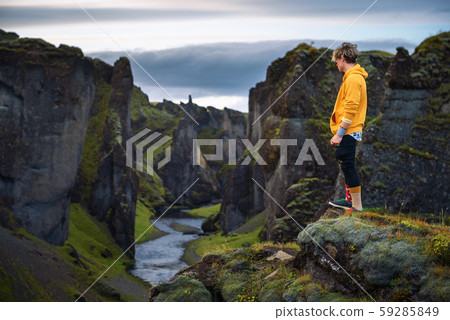 Young hiker standing at the edge of the Fjadrargljufur Canyon in Iceland 59285849